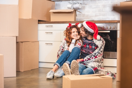 Couple sitting down surrounded by packed boxes