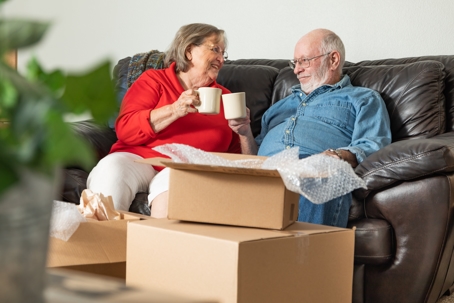 Elderly couple chilling on the couch after moving