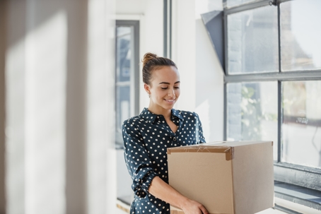 Professional woman carrying a moving box