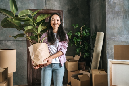 smiling woman holding houseplant