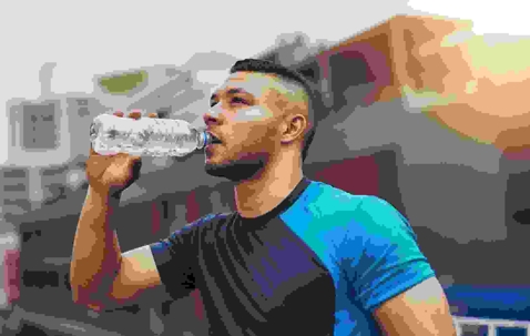 man drinking water wearing athletic clothes
